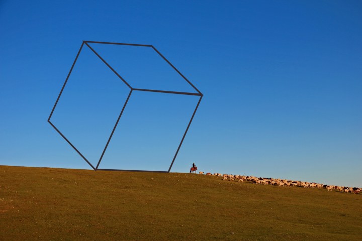 Mongolian herder herding his sheep. Open blue sky and green hills. Crank and Cog blog post, 'Outside the Box'